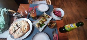 Fresh bread stuffed with kidney beans, aubergine rolls with vegetable filling, pickles, and Georgian pear lemonade at Dze Best Cafe & Restaurant in Brasov