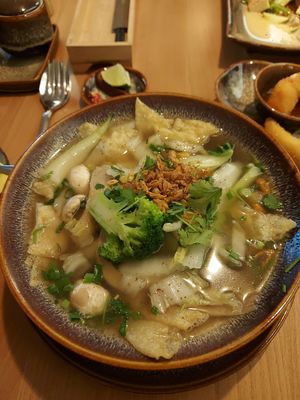 Canh wan tan - tofu, mushroom and veg filled dumplings with wonton noodles and fresh herbs in broth at Miss Vegan in Berlin