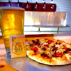 Vegan Personal Pie with vegan sausage and tomatoes. The Rhapsody Pilsner house brew.  at Jemez Mountain Brewhouse in Jemez Springs