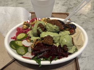My heaping bowl of food/salad 🤤 literally everything that's vegan is in my bowl, toped with the tahini dressing. I hope you like mint! The falafel were AMAZING by the way.   at Brassica in Columbus