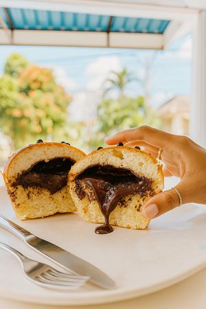 A sliced loaf of Chocolate Bluder from WARMA Vegie Bakery, with rich chocolate filling inside the soft, golden-brown vegetarian bread at WARMA - Vegie Bakery & Coffee Shop in Ubud