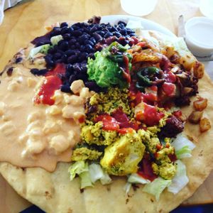 Flying Saucer Full of Secrets: (Mexican breakfast pizza) hominy corn, tofu scramble, chorizo, papas, black beans, guacamole & now with sautéed jalapeños! (available with cheese & sour cream too) at Green New American Vegetarian in Phoenix