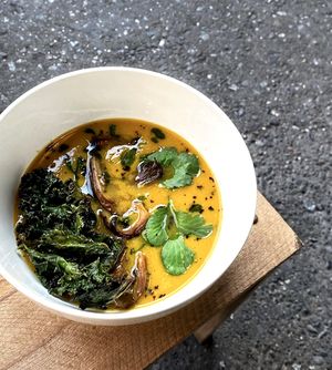 Sweet potato & carrot puree soup w/rosemary, quince, garlic, onion, ginger, sweet paprika, lime juice, served w/baked teriyaki oyster mushrooms & green herbs oil, and kale chips at 2022_place - Pop Up in Yerevan