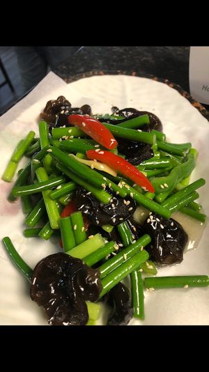Garlic shoots stir-fried with black wood ear mushrooms create a savory, aromatic dish. Tender garlic shoots and earthy mushrooms are paired perfectly for a healthy, flavorful delig at Kungfu Kitchen in Reading