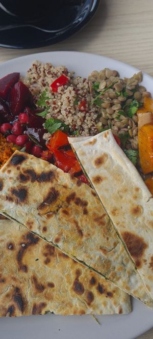 Spinach and onion flatbread, with a selection of salads. I've been craving this ever since! at Busy Beans Cafe in Redhill