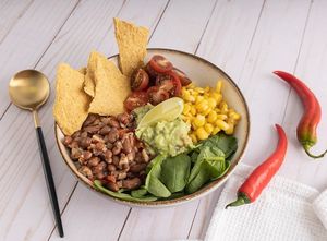 Burrito bowl with a side of raw corn crackers  at Pumpkin and Kale  in Dubai