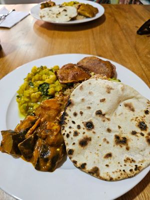 Eggplant curry, chickpea curry, rice, fritters and flatbread at Ahimsa - Maybe closed in Managua