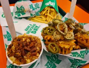 Mac n cheeze, fries, loaded jalepino waffle fries and (wrapped) sneaky clucker burger at Oowee Vegan in Brighton