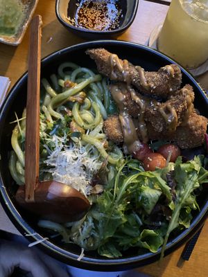 Green pesto udon noodles with fried mushrooms and cooked cocktails tomatoes, salad and vegan Parmesan   at Shisomen in Berlin