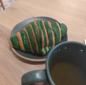 The pistachio Croissant with herbal mountain tea at Holy Llama - Sintagma in Athens