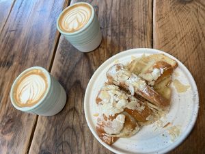 Flat white coffees and almond croissant   at Fire & Flow Coffee Roasters in Cirencester