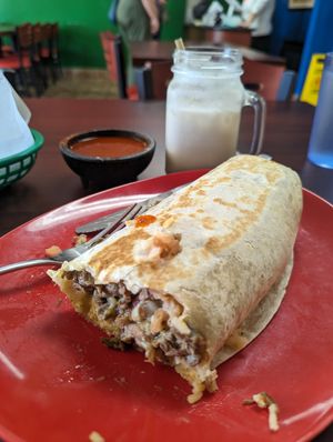 Carne Asada Burrito with Horchata in the background at El Cantaro Vegan Taqueria in Sacramento