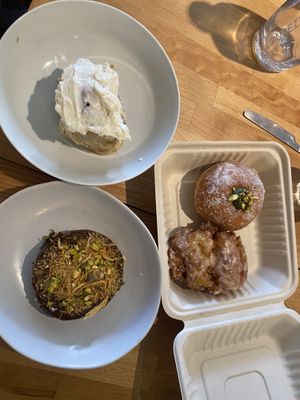Clockwise from top: bestselling cinnamon scroll, pistachio cream doughnut, pear fritter, Dubai Chocolate cookie  at Miss Sina in Marrickville
