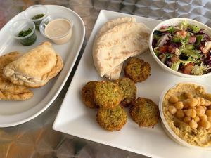 Sample Plate with sambousek, falafel, hummus, side salad, pita bread and sauces at Beyond Falafel in Quarteira