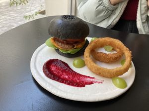 Burger with black bun, onion ring, and beet sauce   at ARP - 아르프 in Busan