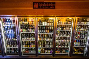 12 door reach-in cooler with hundreds of bottles and cans of bottled beer, cider, sake, wine, and non-alcoholic beverages like kombucha! at Broken Top Bottle Shop and Ale Cafe in Bend