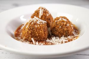 Arancinis in a Marinara Sauce and topped with Parmesan at Veganarie - Resto Végan in Montreal