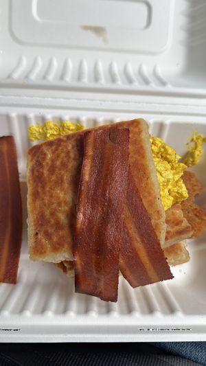 The Potato bred with bacon sausage and tofu scramble to take away. Comes with brown and red sauce   at The Nutmeg in Holywood