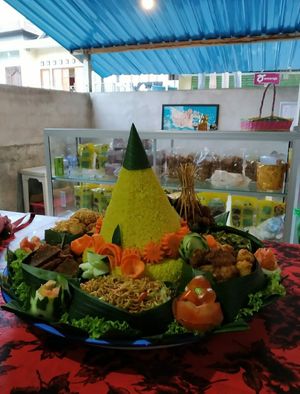 vegan rice cone with a cone shape and surrounded by side dishes and vegetables is a symbol of the ecosystem of life. at Vegan Sentana - Jaya Stall in Semarapura
