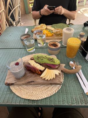 Hammam chill breakfast - avo and hummus on toast, chia pudding, fruit, juice and coffee! Pikala breakfast in the background (veggie)  at Pikala Cafe in Marrakech