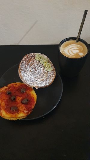 Latte, tomato and olive bread and a pistachio cream filled bun at The Sanctuary in Berlin