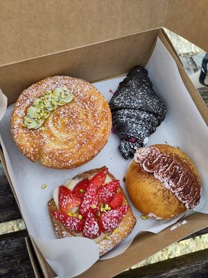 Pistachio girella, raspberry and white chocolate cornetto, strawberry and vanilla tart, and chocolate maritozzi 😍  at The Sanctuary in Berlin