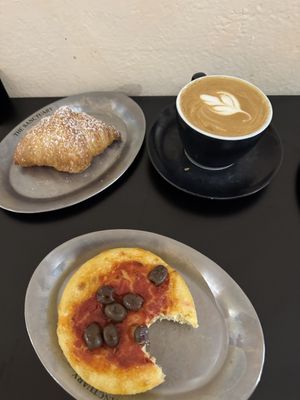 Vanilla croissant, flat white and a tomato sauce and olive mini-pizza  at The Sanctuary in Berlin