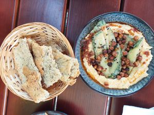 'Ginger Hummus' with chili oil, marinated cucumber, tahini and miso sauce served with crackers and roasted chickpeas (11.50€) at Creativa in Ingolstadt