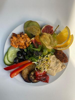 Mediterranes Frühstück mit Ciabatta, Kräuter-Oliven, Grillgemüse, Hummus, Tomatenbutter, Pesto, Rohkost und Obst  at Café Warenannahme  in Hannover