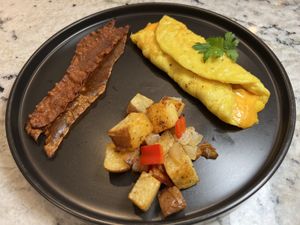 Just egg omelette with Violife cheese, breakfast potatoes and rice paper bacon   at Plant Based Trace in Gainesville