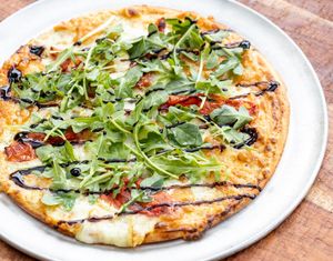 White Cheese, Tomato & Arugula Personal Pizza: A white cheese and herb blend melted on a crispy gluten-free cauliflower crust with roasted seasoned tomatoes topped with fresh arugula. at worldFLATS - Ridgewood in Ridgewood