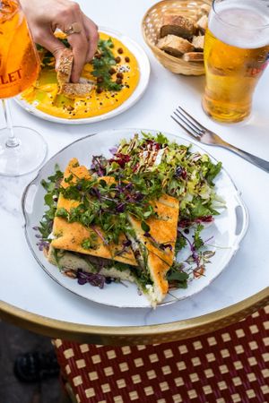 FOCACCIA AUBERGINE
Focaccia aubergine grillée, tomates séchées, pesto de cerfeuil, crème de balsamique, roquette et mozzarella, servie avec salade

Possibiilté feta vegan at La Luck in Brussels