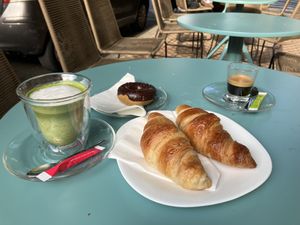Matcha latte, espresso, croissant and a chocolate donut.  at Fraise Café in Menton