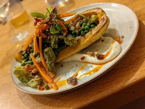 Delicata squash with peas, fermented carrots, fried shishito peppers, and a garlic toum sauce. at Driftless Cafe in Viroqua
