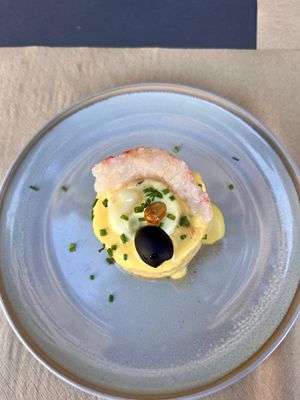 Causa stuffed with vegetable tuna, topped with shrimp, and garnished with a black olive at Los Andenes Vegan - Puerta de Toledo in Madrid