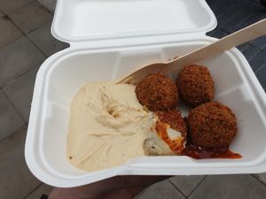 4 piece falafel with hummus and a little bit of chilli sauce at Falafel King in Manchester