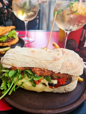 Sándwich berenjenas apanadas en harina de garbanzo y panko, Pimientos asados, rucula, pesto tomate y quedó vegan at Fuente Rica Rica - Plaza Ñunoa in Santiago