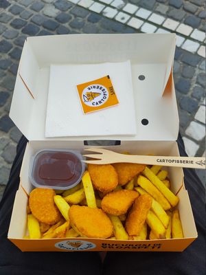 Vegan nuggets, chips, and a pot of ketchup, in a take-away box with a wooden fork at Cartofisserie in Brasov
