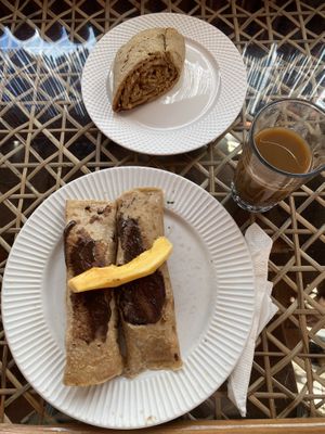 pancakes with fresh fruit and chocolate sauce, cinnamon roll & iced coffee  at Baobab House in Cape Coast