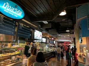 Still open, Sept 15, 2017. Coming from the cashier stand, the stall is on the first row to your right. it will be on your left, after walking toward the front. Note the ";london bridge"; in background.  at BKK - Veg Stall Food Court - T21 in Bangkok