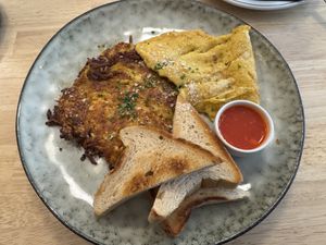 Veganes Rösti mit Kräutern, dazu ein luftiges Kichererbsen-Omelett, geröstetes Brot und ein Dip mit Chili.  at Ti's Café in Minheim