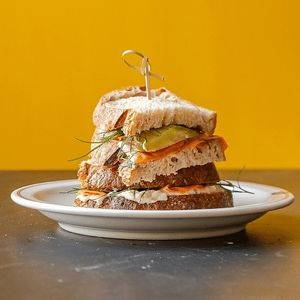 De Smoked Garden - A sourdough sandwich with thin slices of smokey and sea-flavoured carrot, on a white bean spread, topped with pickles and dill.  at Wildflower Canteen in Leiden