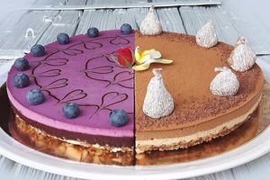 Two-kind raw vegan fig-chocolate and blueberry cake decorated with dried figs, live blueberries, chocolate artwork and live flowers. at Raw Planet in Prague