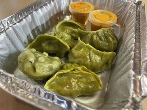 The Veggie Momo! Steamed dumplings with a tasty filling of fresh cabbage, onion, spring onion, carrot, spinach, ginger, garlic, and spices. Get the tomato chutney as the sauce.   at MomoDosa in Minneapolis