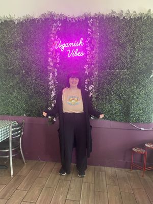 Taking a picture by their cute wall   at Veganish Vibes in Baton Rouge