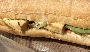 Tofu, cashew creme, mushroom, zucchini, and red bell pepper sandwich sitting on its takeaway wrapping   at Atelier Dulce Amarui in Cluj-napoca