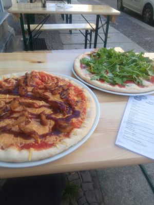 Links eine vegane Pizza mit Barbecue Sauce und "Chicken" aus Sojageschnetzeltem, leckerer Teig, rechts nichtvegane Mozzarella-Pizza at lecko mio! in Leipzig