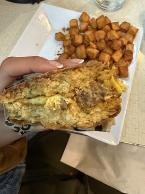 Not a great pic, but I was so excited to eat I forgot to take a nice one before. Chive biscuit with vegan egg, cheddar, and sausage. 🤌🏽  at Square Cafe in Pittsburgh