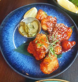 KOREAN FRIED CAULIFLOWER: Crispy cauliflower tossed in gochujang with sesame, coriander & pickled cucumber at Bill's in Manchester