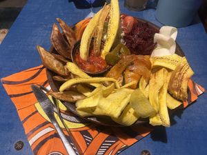 Jollah bowl with handcut plantain chips, fries and array of vegetables with rice  at CasaTeranga PlantBaseDakar in Dakar